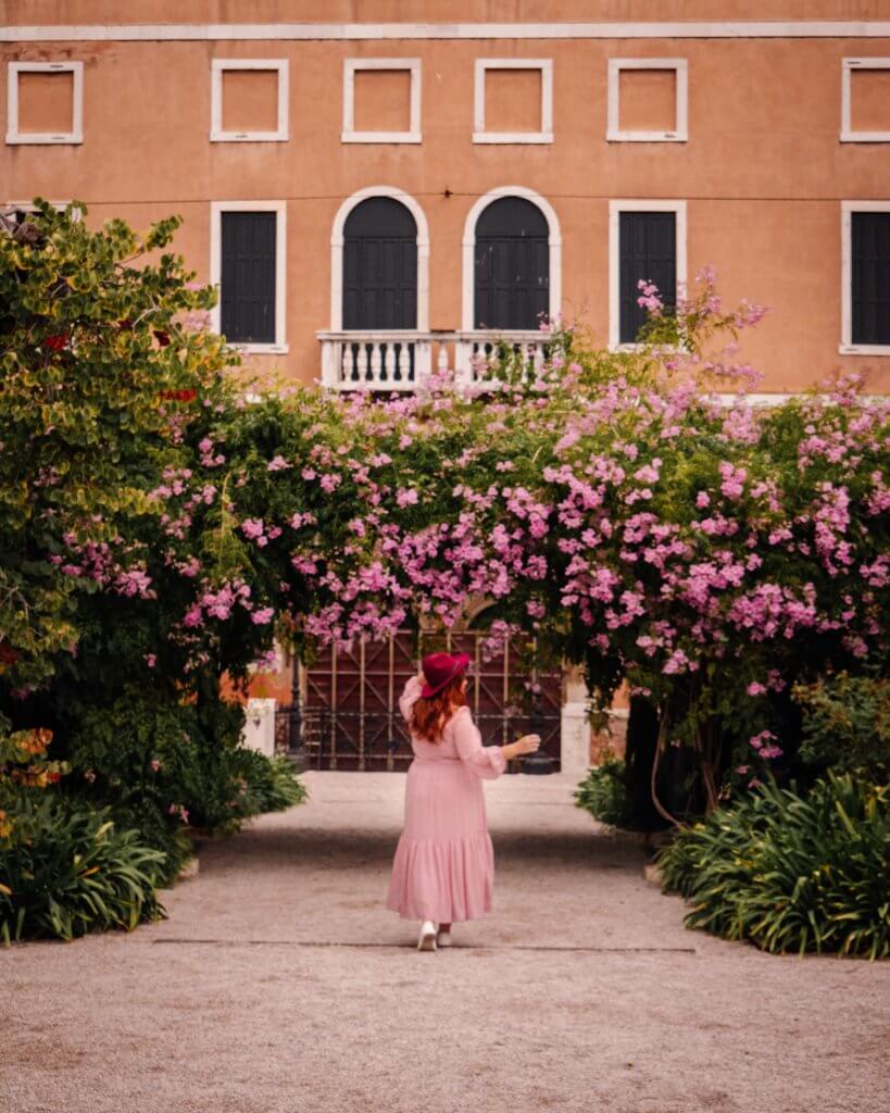 Woman walking among flowers at Giardini Reali gardens in Venice Italy