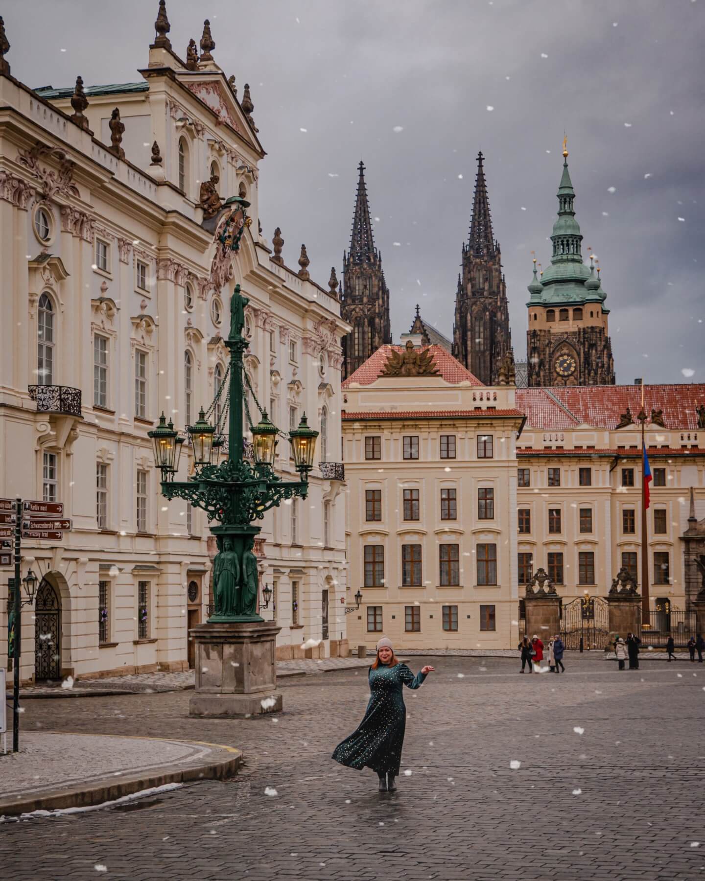 Woman in a green dress at nový královský palác in snowy Prague