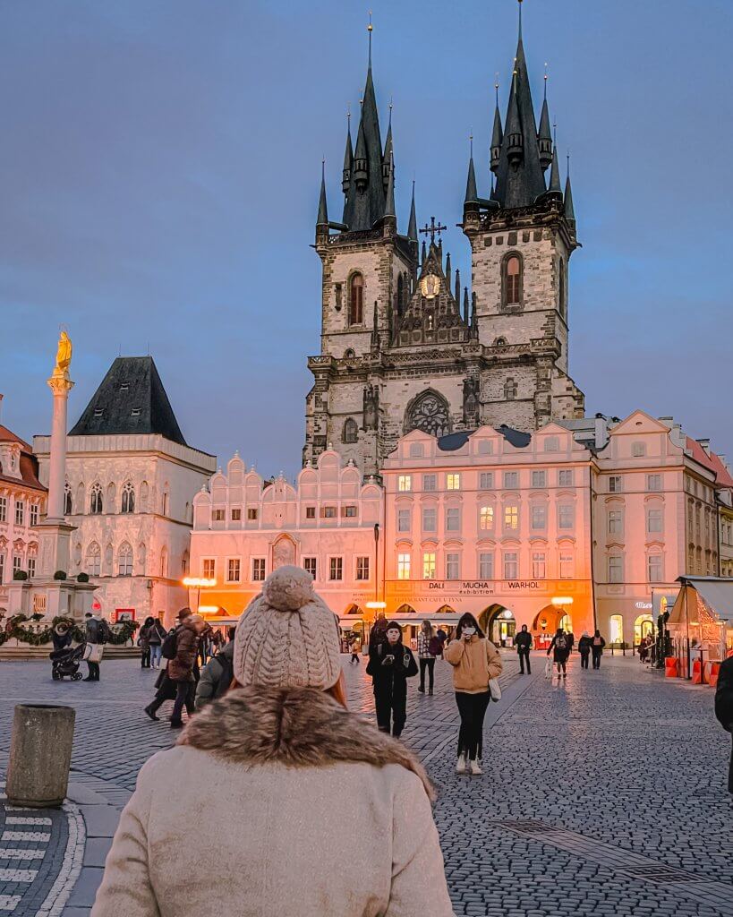 Woman in a wool hat and coat in the old town square of Prague during 2 days in Prague