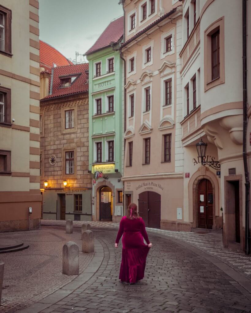 Woman walking down a cobblestone street in old town Prague