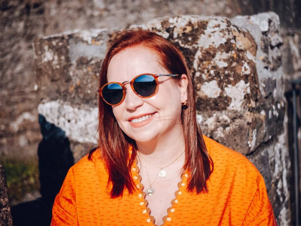 Irish woman with red hair wearing Persol sunglasses a must have travel accessory