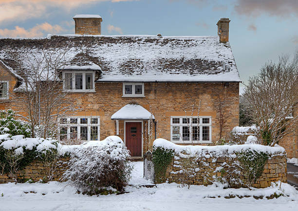 Pretty Cotswold cottage in snow, Broadway, Worcestershire, England.