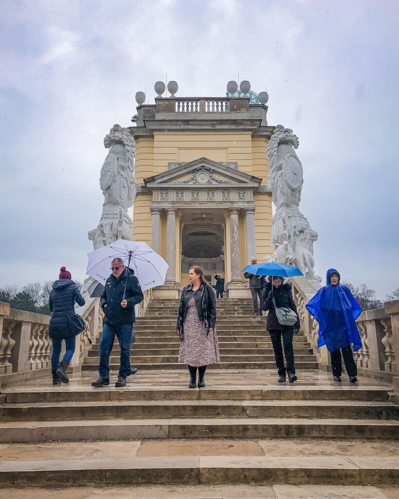 People walking in the rain at Gloriette in  Schonbrunn Palace in Vienna