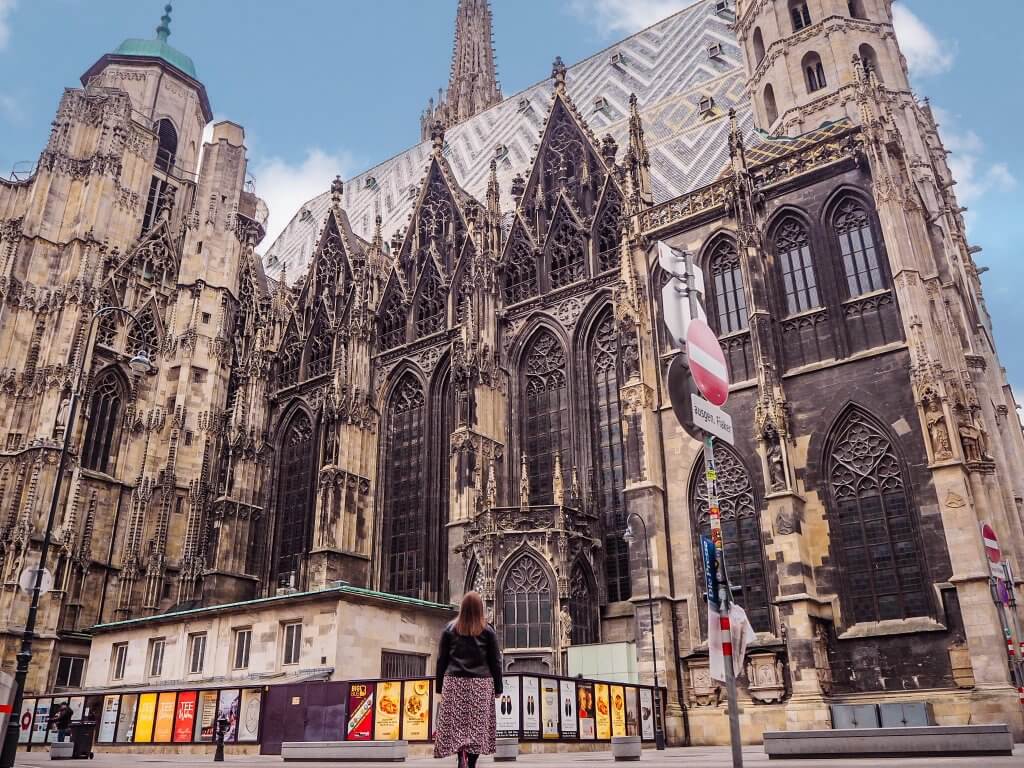 Woman looking up at St Stephens cathedral in Vienna Austria