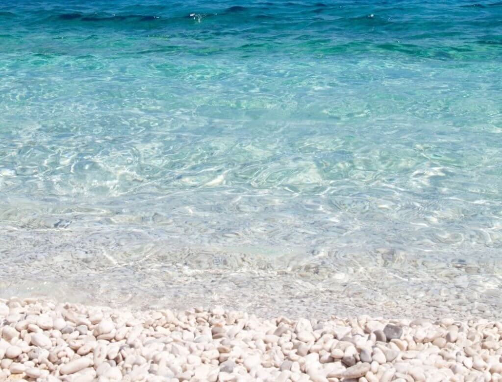 Crystal blue water and pebbles on Assos Beach
