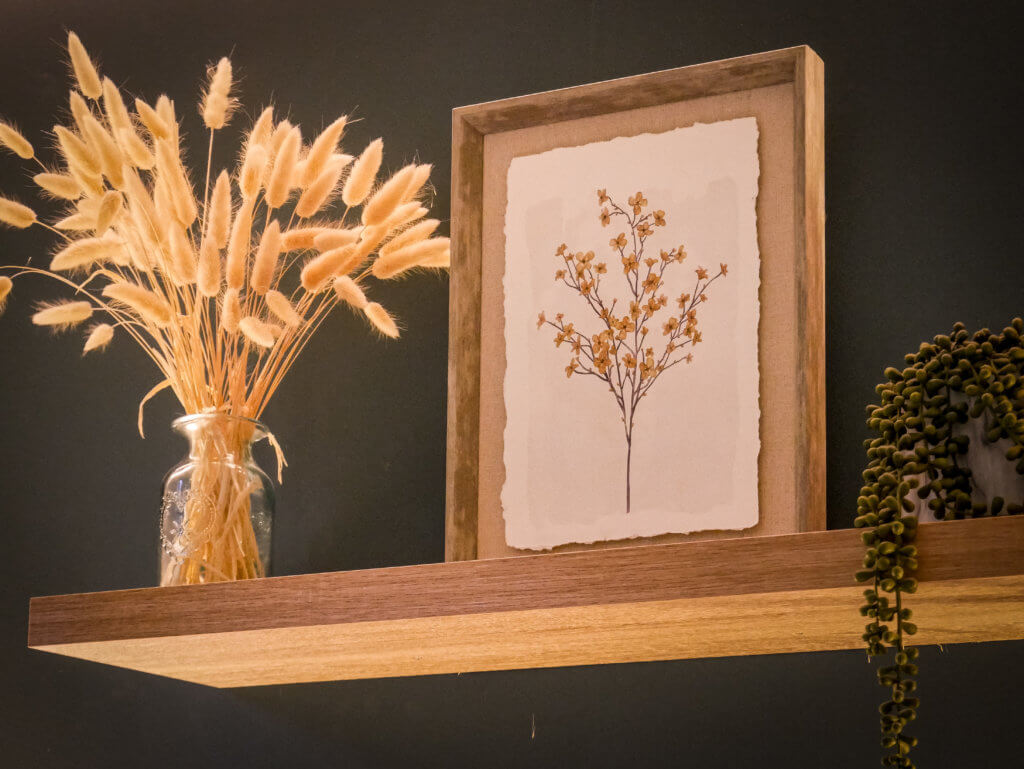 Shelf with a picture frame, vase and a plant