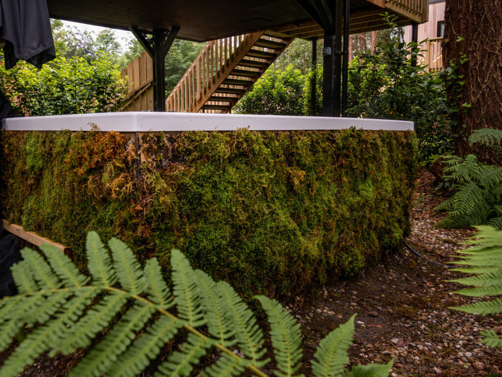 Moss covered hot tub at treehouse accommodation in Ireland