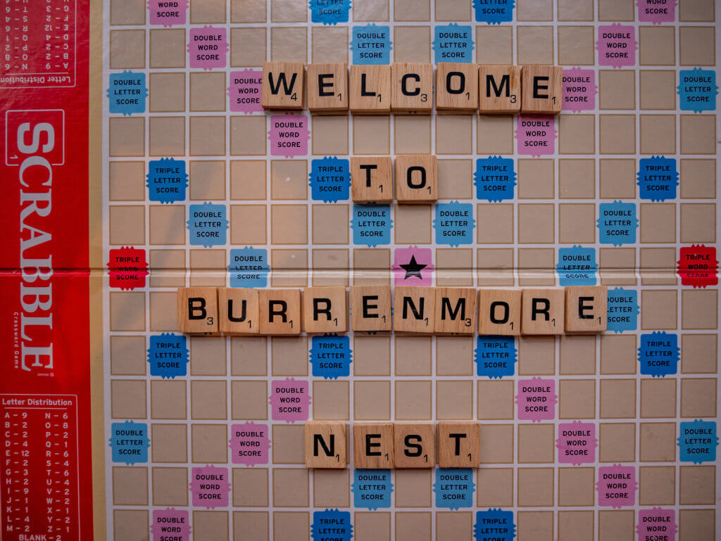 Scrabble board reading welcome to Burrenmore Nest