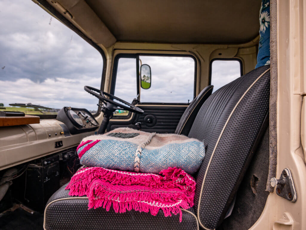 Vibrant coloured wool blankets folded on the seat of a converted Bedford Horsebox.