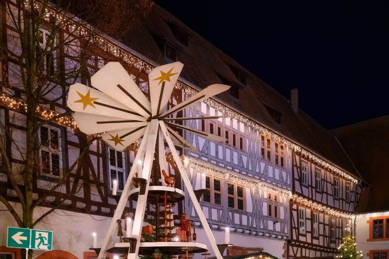 Charming half-timbered houses in Michelstadt adorned with holiday decorations and snow.