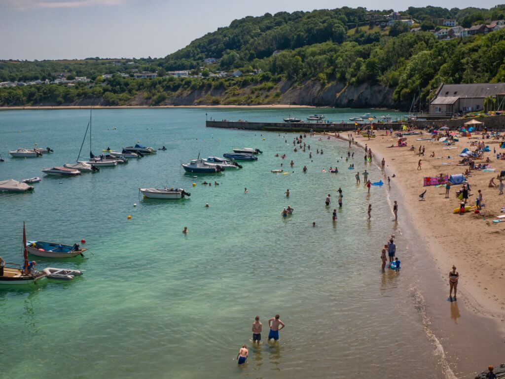 People enjoying the beach on New Quay Wales on a sunny day