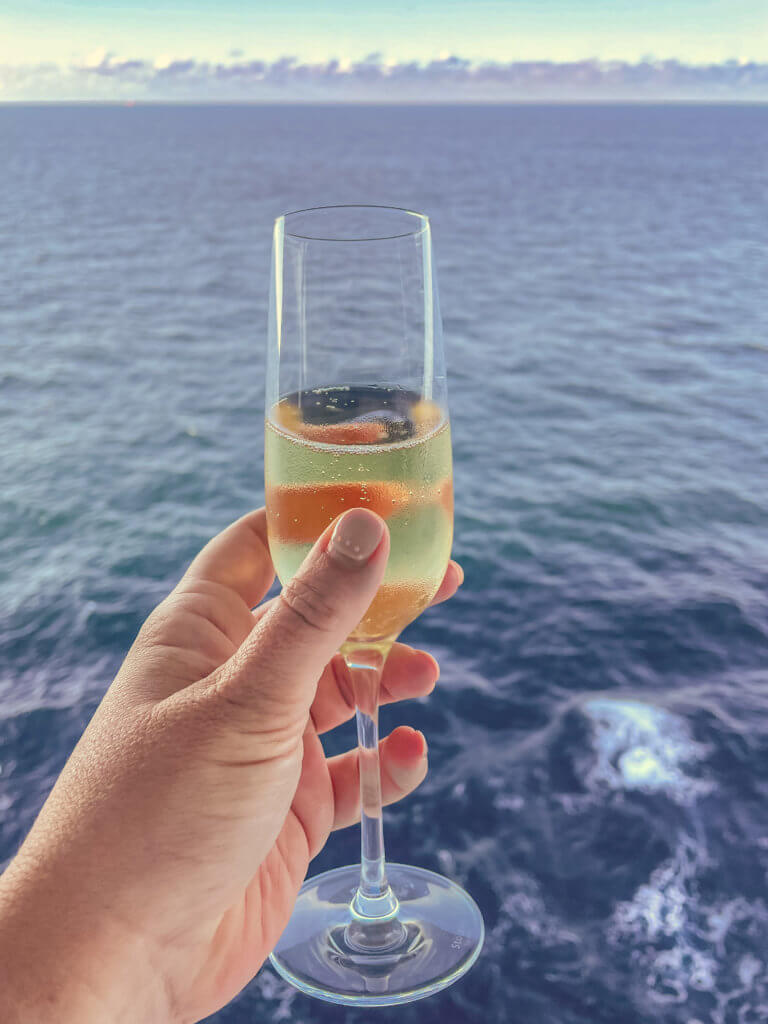 Woman holding a champagne flute on her first cruise