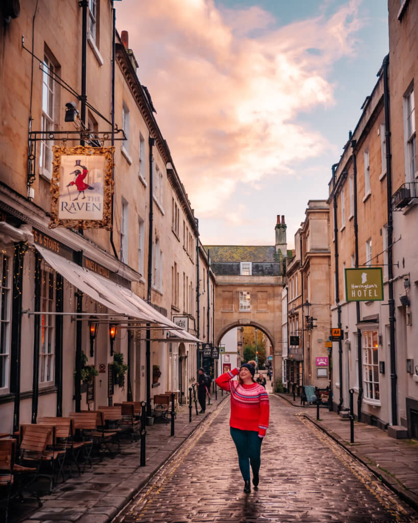 Woman in a christmas jumper walking along the streets of Bath during Christmas