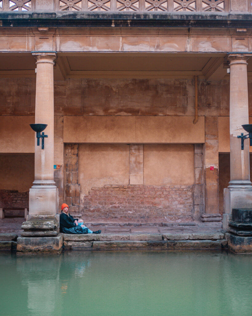 Woman sitting at the Roman Baths in Bath UK