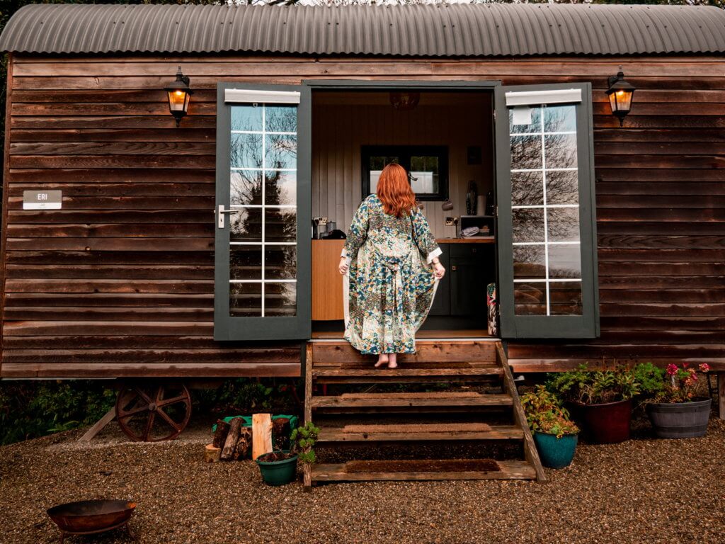 Woman walikng into a rustic cabin wearing a luxury kimono verry kerry robe