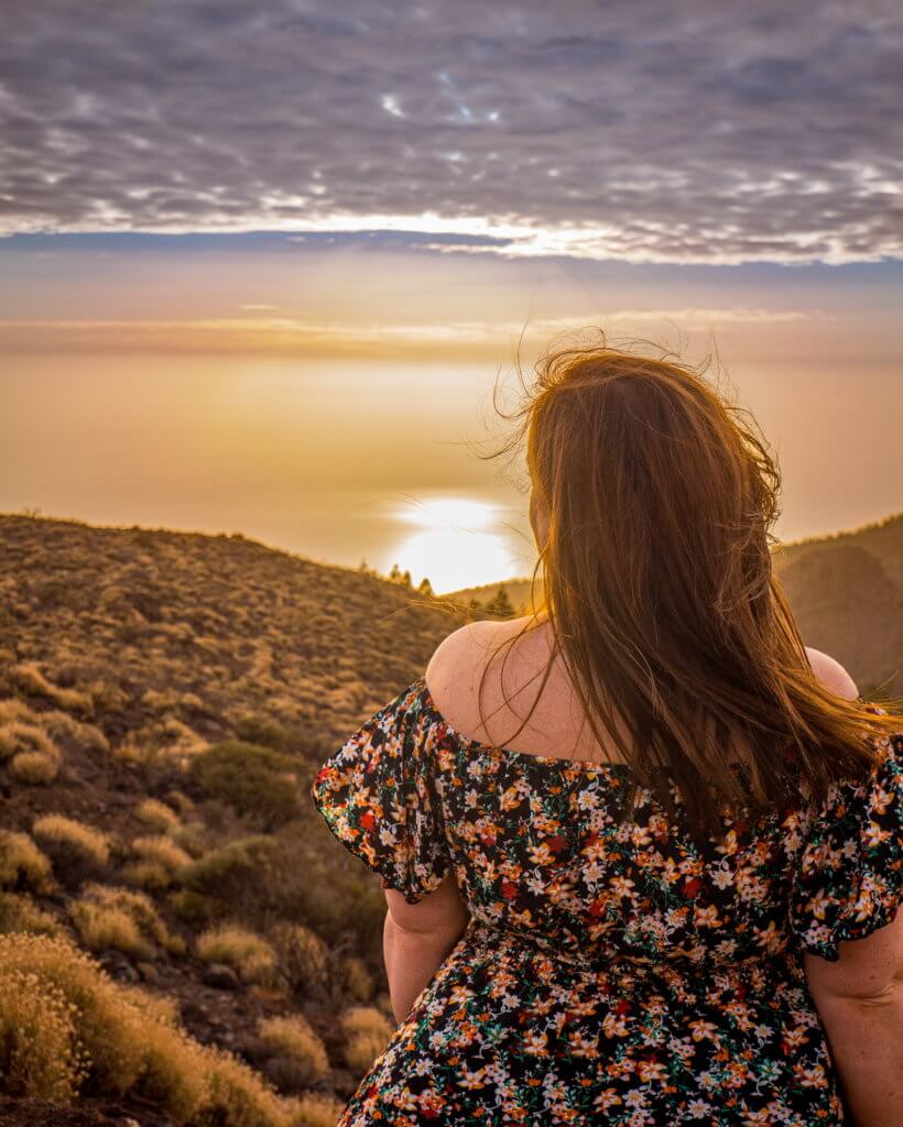 Woman in a floral dress standing on Mount Teide in Tenerife at sunset