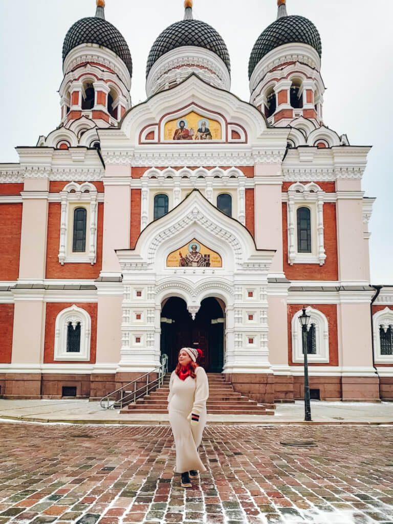 Woman wearing a hat, gloves and scarf standing in front of Alexander Nevsky Cathedral