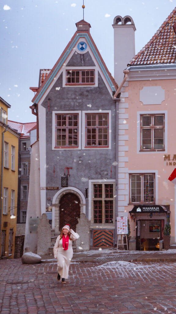 Women walking in the Old Town Square of Tallinn while it is snowing