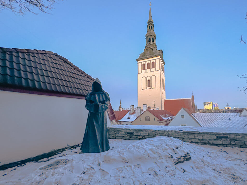 Praying monk statue in the snow at the Danish Kings Garden Tallinn