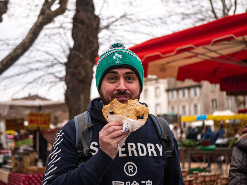 Man eating a pastry at Carcassonne Food Market