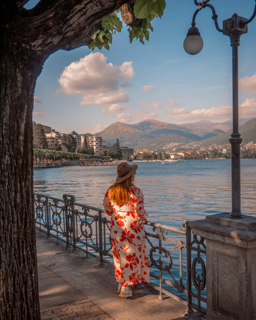 Nicola wearing a floral dress looking at the view of Lake Lugano in Switzerland