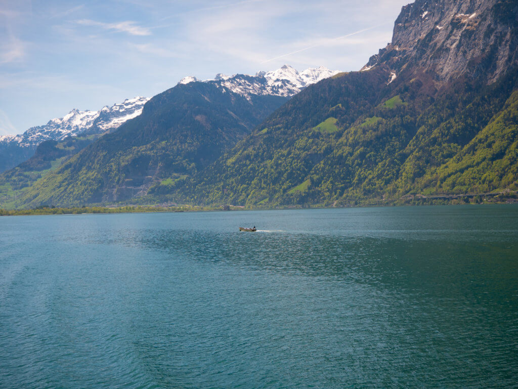 Person in a boat on Lake Lucerne surrounded by snow capped mountains