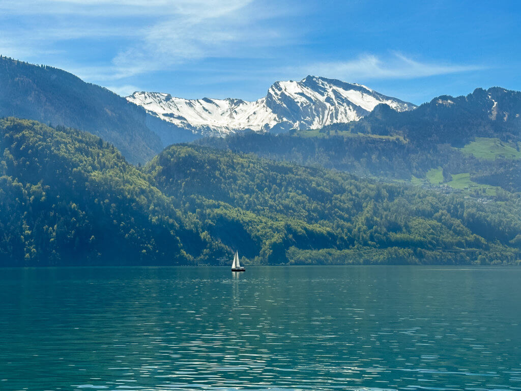 Sailboat surrounded by snowcapped mountains on Lake Lucerne