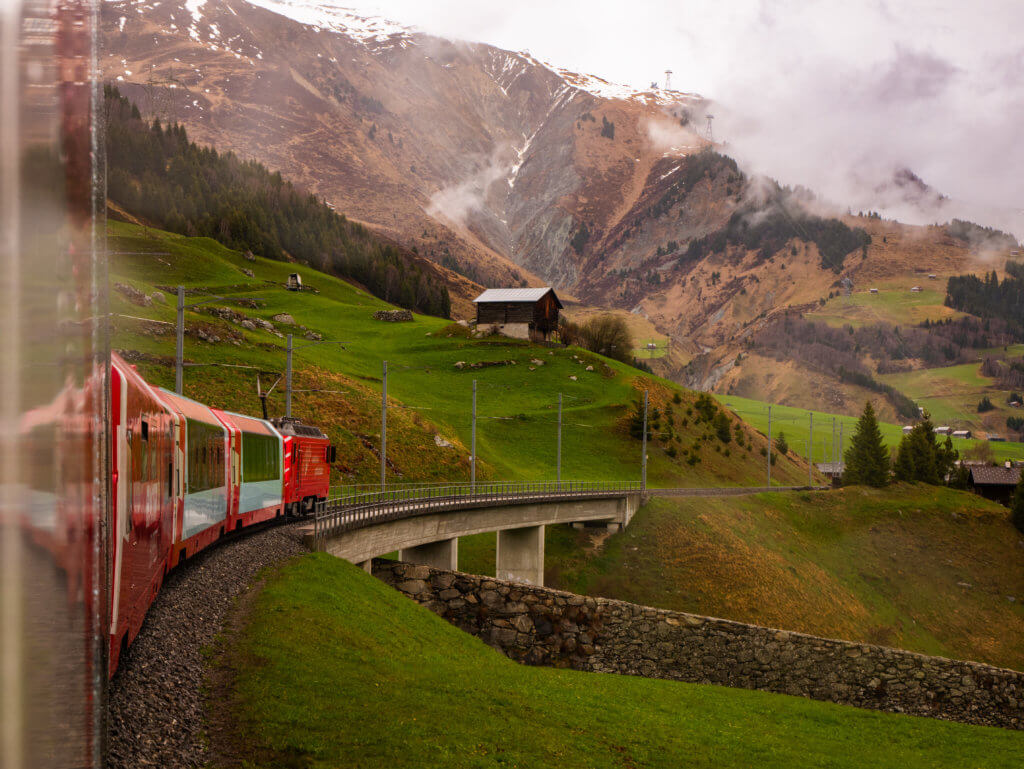Glacier Express panoramic train travelling along train tracks in Switzerland