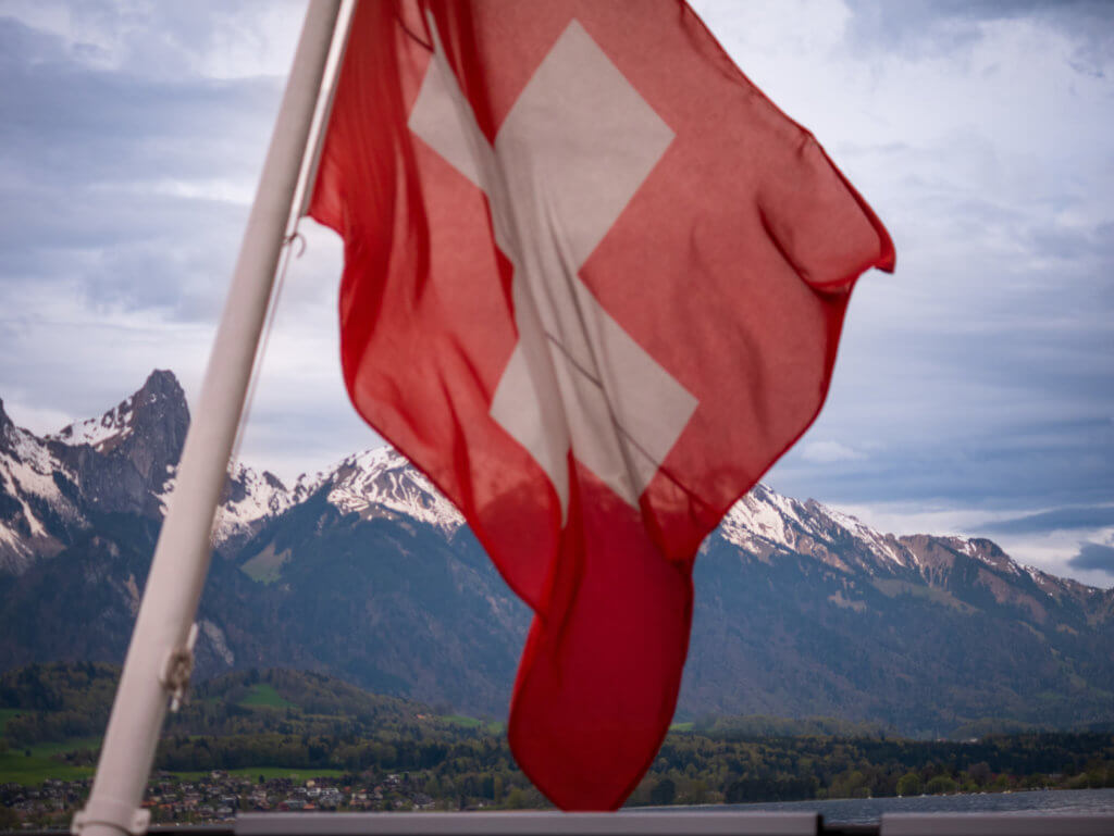 Swiss flag with the Swiss Alps in the background