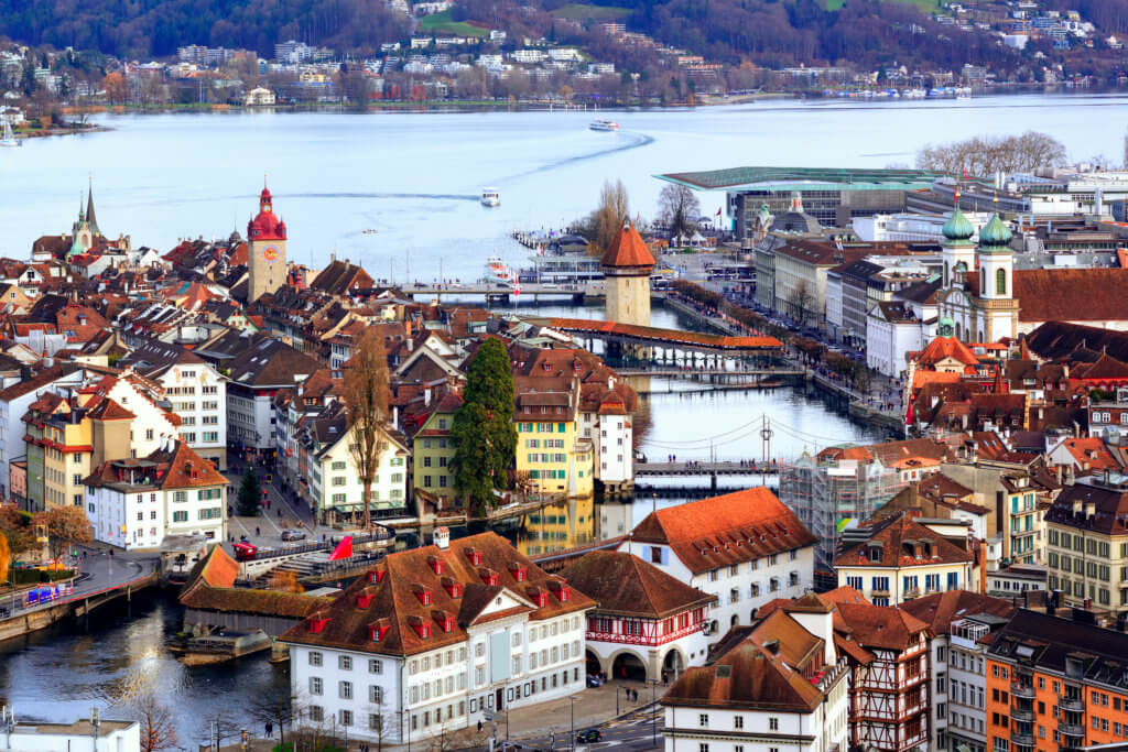 Aerial view of red tile roofs of the old town of Lucerne city covered in snow