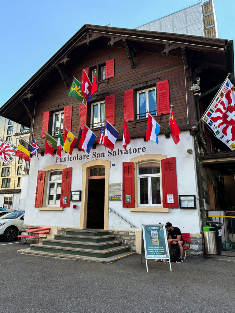 Swiss building with flags. Exterior of the entrance to Funicolare San Salvatore.