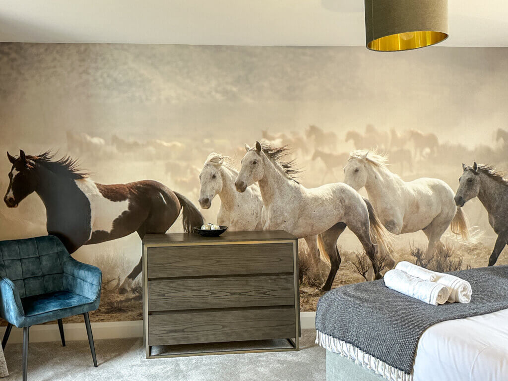 Unique decor in a bedroom of a holiday property in Northern Ireland. Wall mural of horses running.
