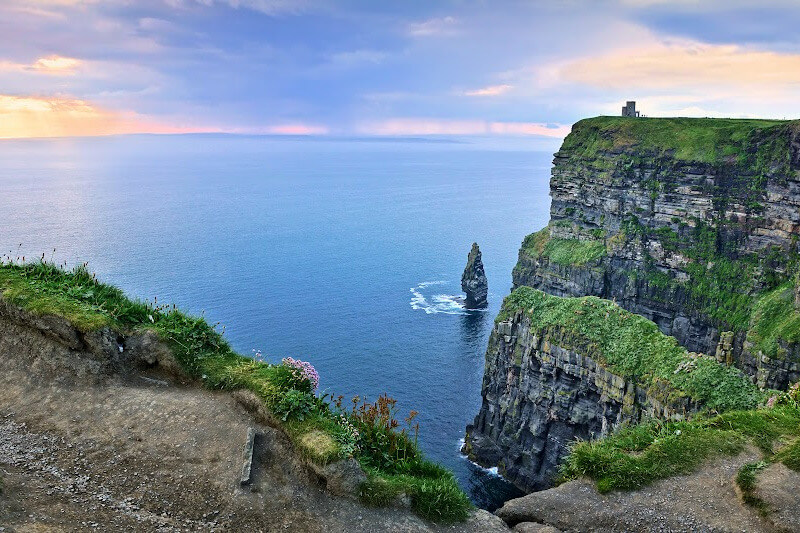 The wind whispers secrets of the past as you stand on the edge of the Cliffs of Moher.