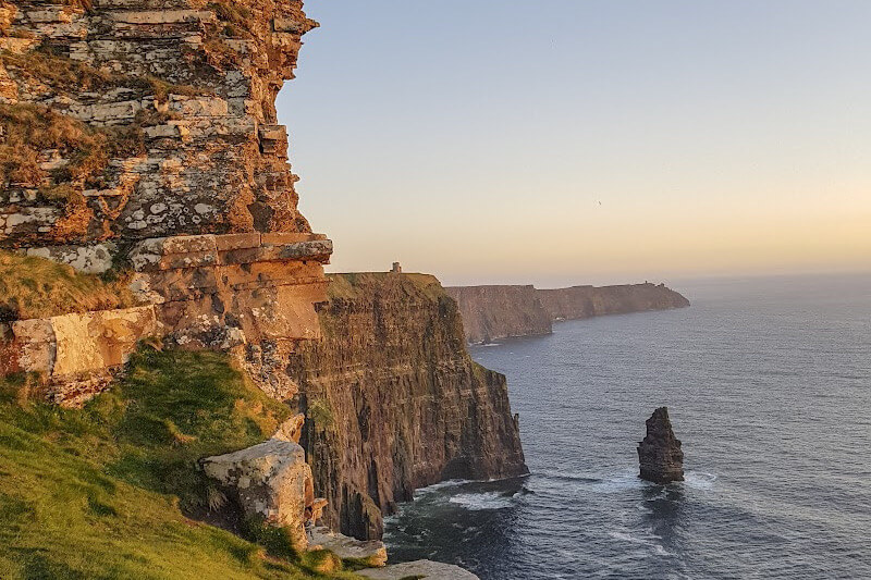Feeling the power and beauty of nature at the dramatic Cliffs of Moher at sunset, a must-see in Ireland.