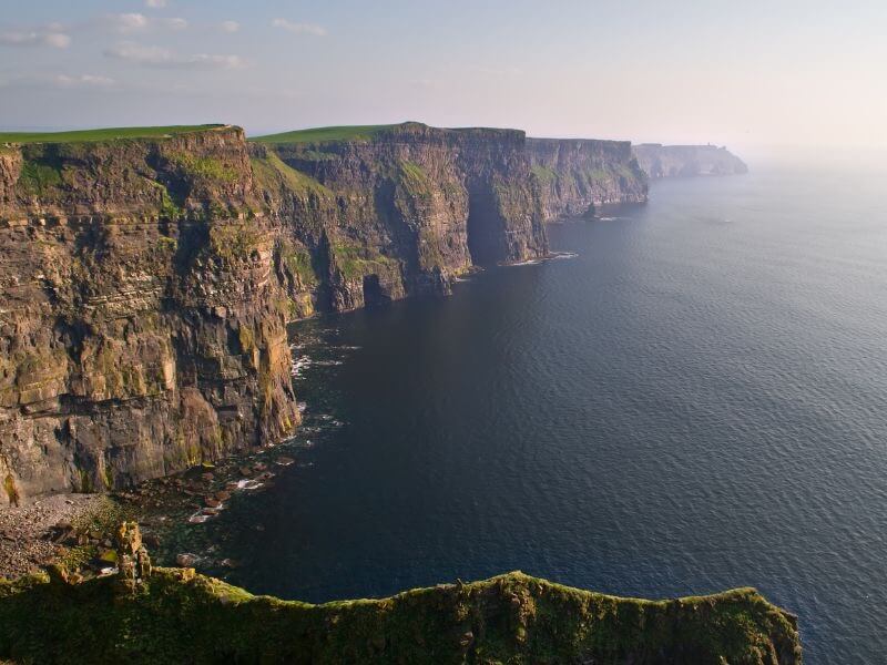 The awe-inspiring Cliffs of Moher, Ireland, standing tall against the vastness of the Atlantic Ocean
