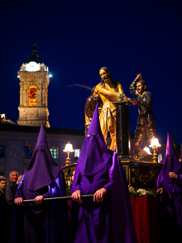 Malaga's Easter parade: Participants dressed in traditional attire, carrying candles and incense as they march through the city.