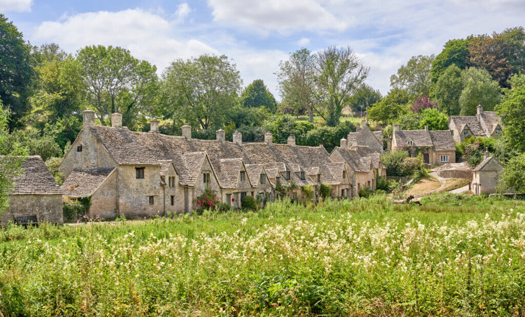 Charming cottages of Arlington Row in Bibury during a summer day in the Cotswolds.