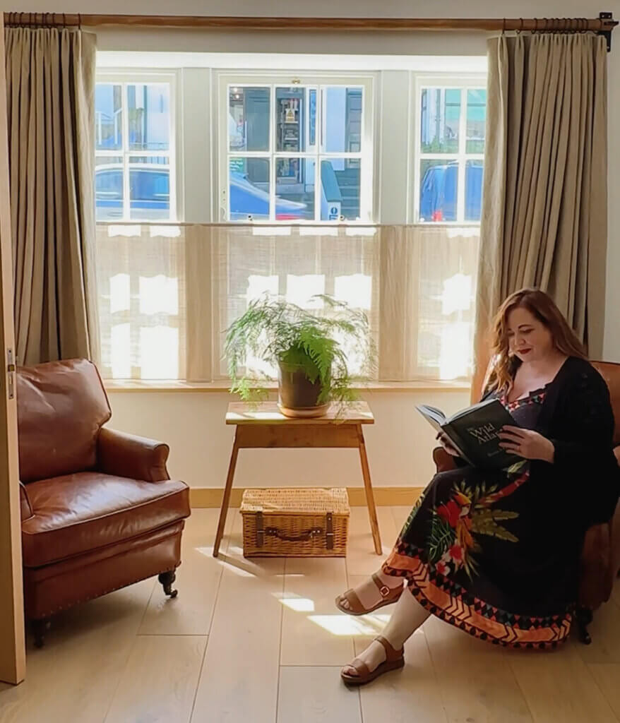 Nicola Lavin, an Irish travel blogger, reads a book on a cosy armchair in Within the Village, a luxury self-catering property in Roundstone, Connemara.