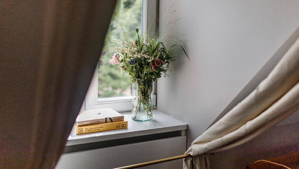 Vase of flowers on a windowsill of Hotel Gerbermühle boutique hotel