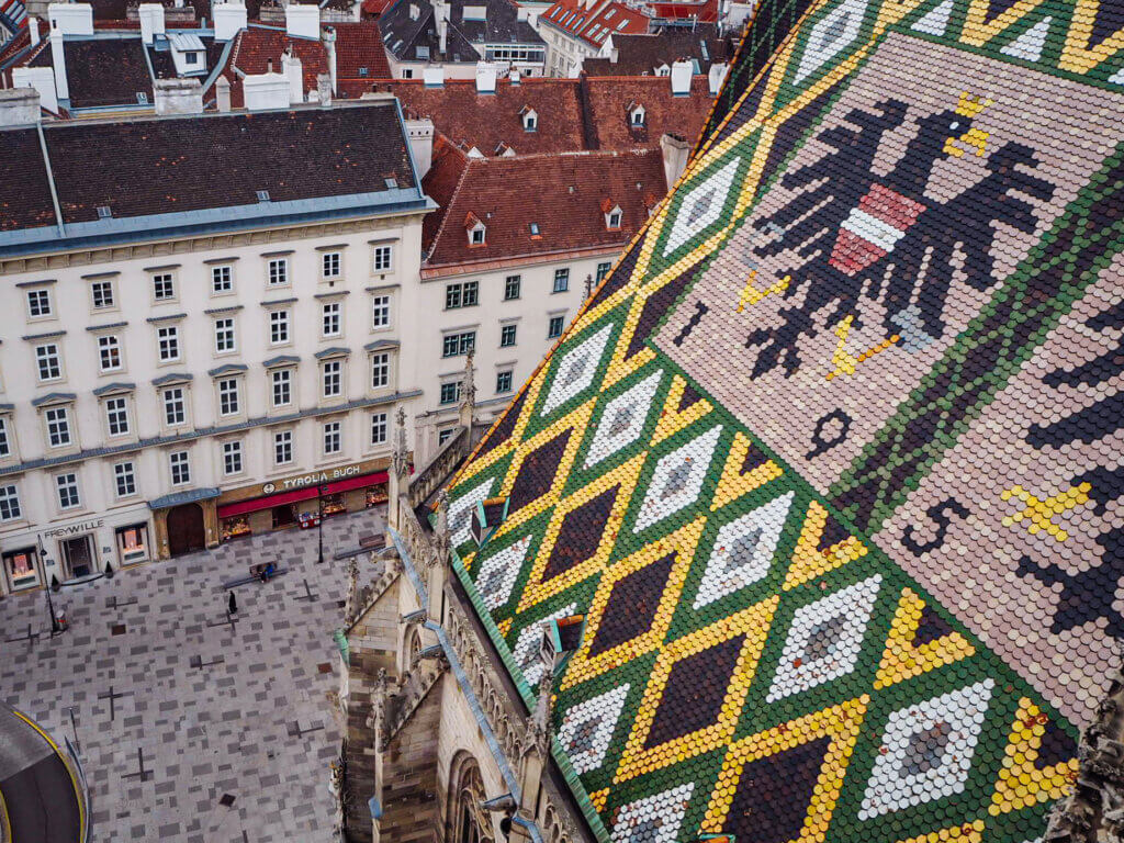 Aerial view of the mosaic-tiled roof of St. Stephen's Cathedral and the square below. How to Spend 3 Unforgettable Days in Vienna.