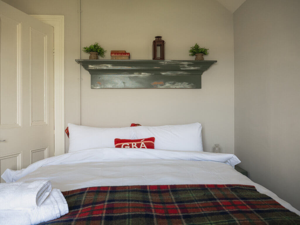 Bright and cosy bedroom inside the Loop Head Lighthouse cottage, featuring coastal decor.