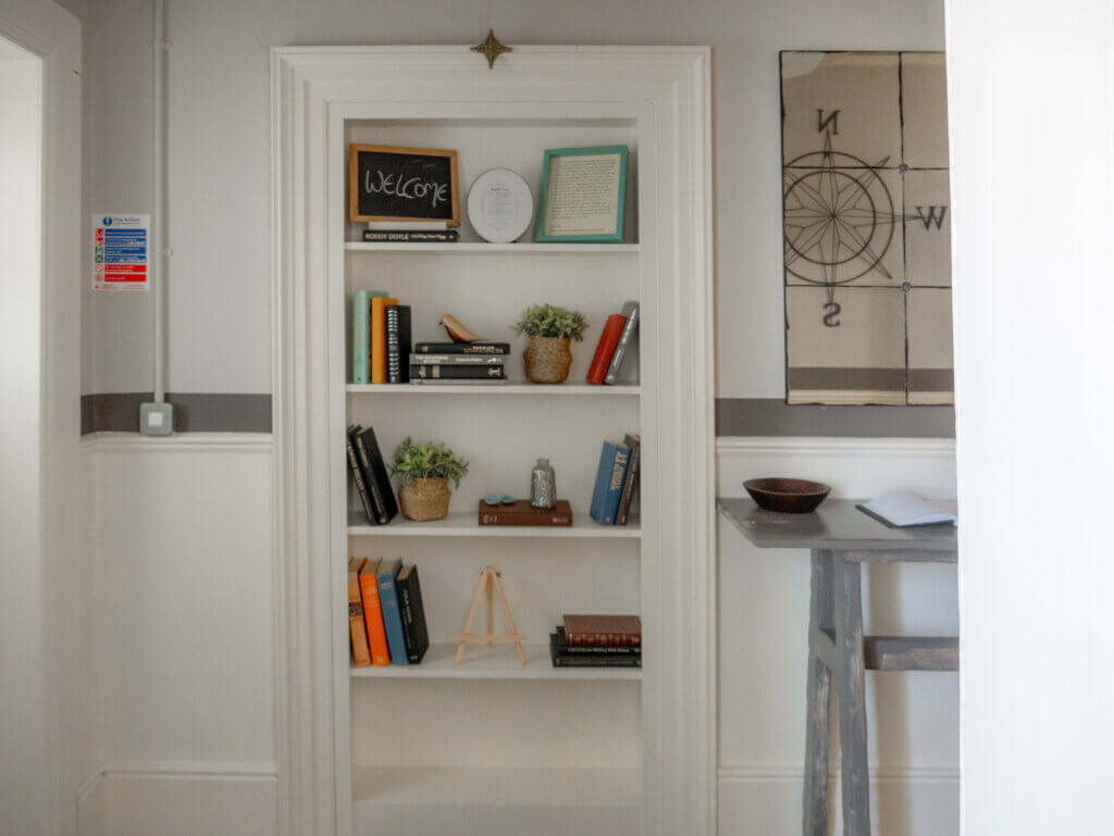 A bookshelf inside the lighthouse cottage, filled with books on local history and nature.