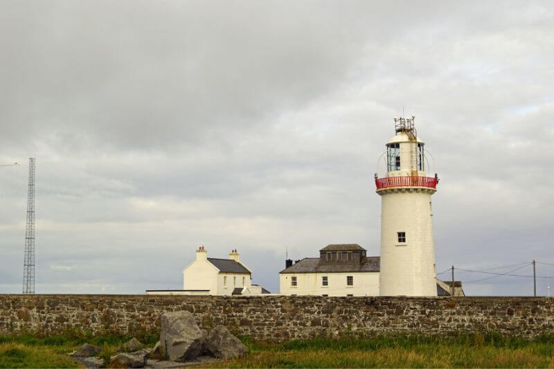 Loop Head Lighthouse with seagulls flying overhead, capturing the coastal atmosphere.