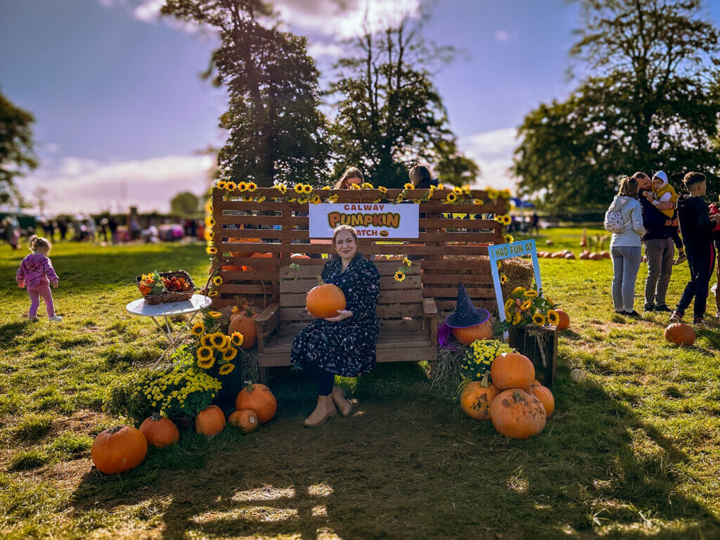 Woman holding a pumpkin at Galway Pumpkin Patch in Ireland.