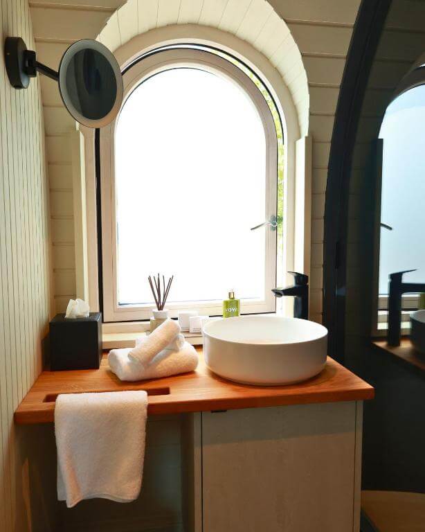 Modern ensuite bathroom with rainfall shower and sleek finishes in a luxury cabin in Ireland.